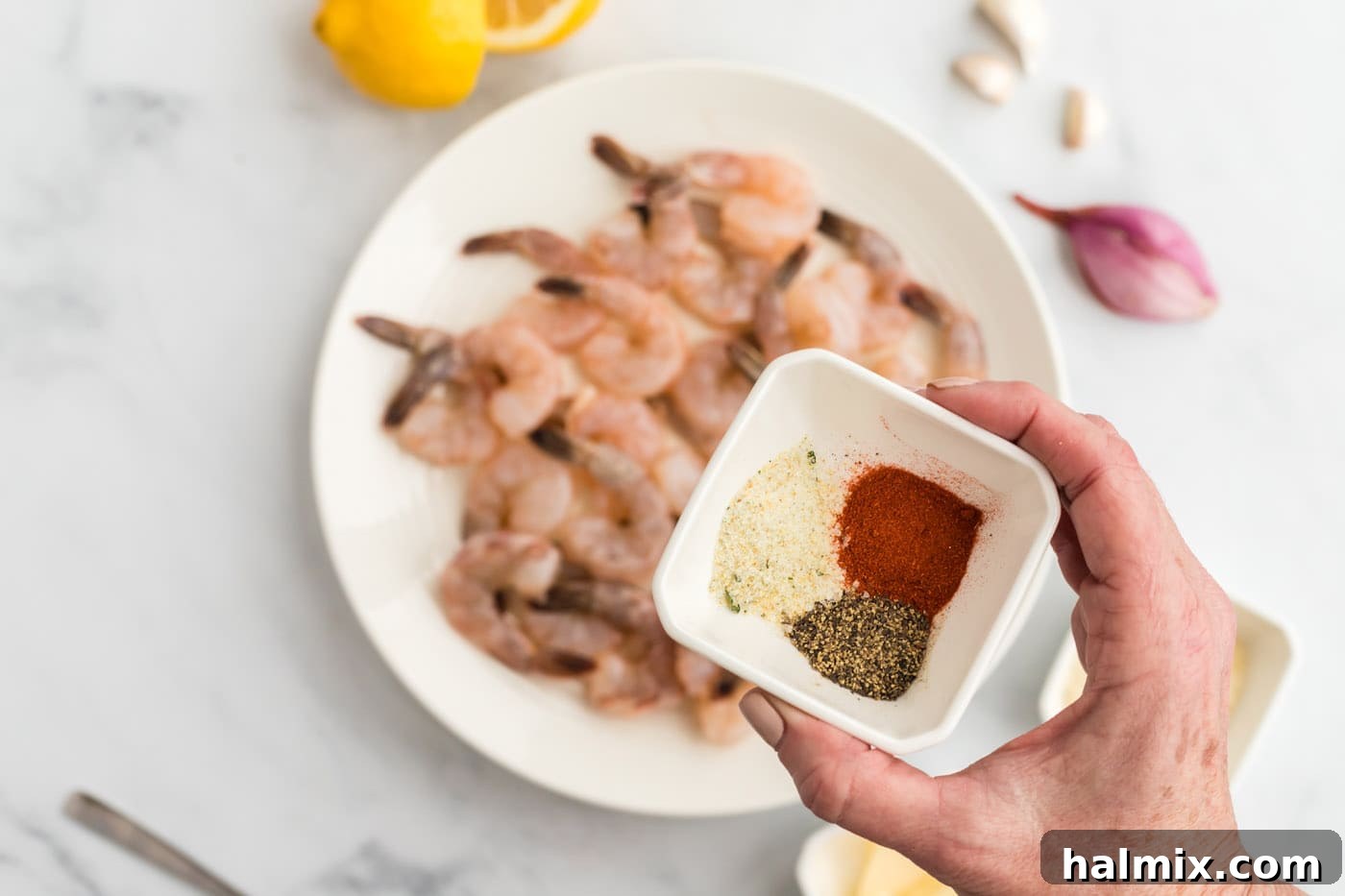 Small bowl containing paprika, garlic salt, and black pepper for seasoning shrimp.