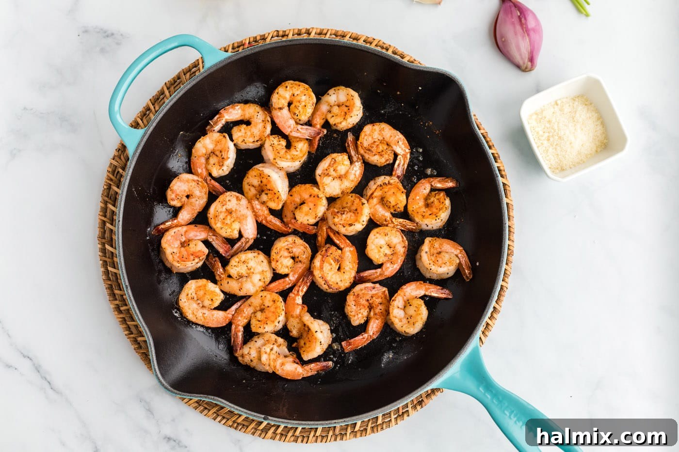 Shrimp cooking in a hot skillet with melted butter.