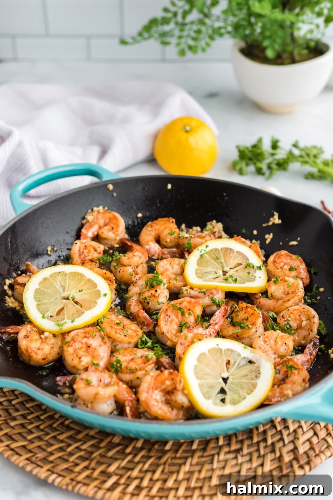 Close-up of a skillet filled with perfectly sautéed shrimp, garnished with fresh parsley.