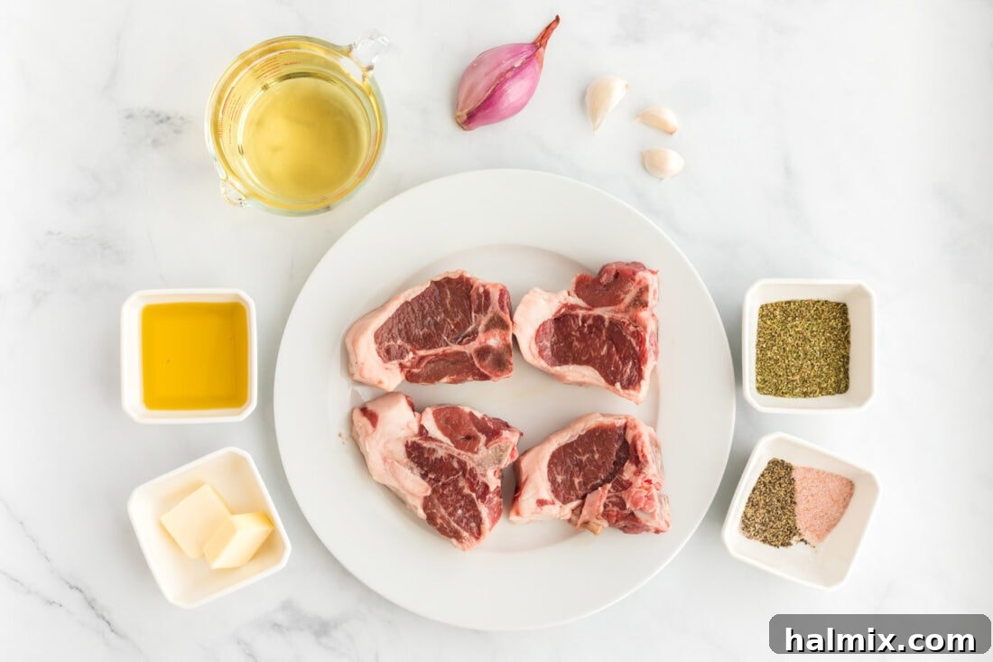 A collection of fresh ingredients laid out on a table, including lamb chops, olive oil, garlic, shallots, white wine, and butter.