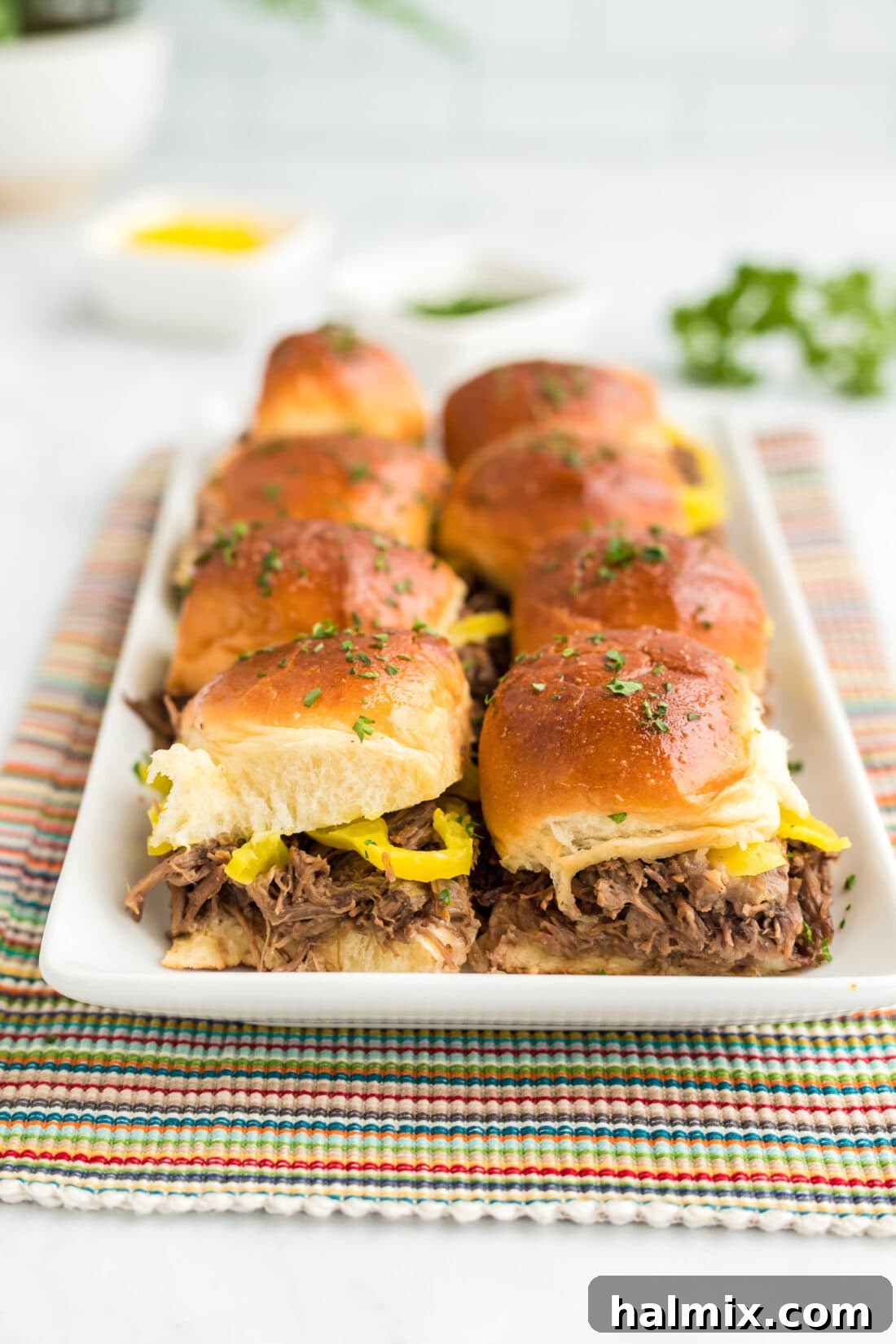 A beautifully arranged platter of Mississippi Pot Roast Sliders, ready to be served at a party or family gathering.