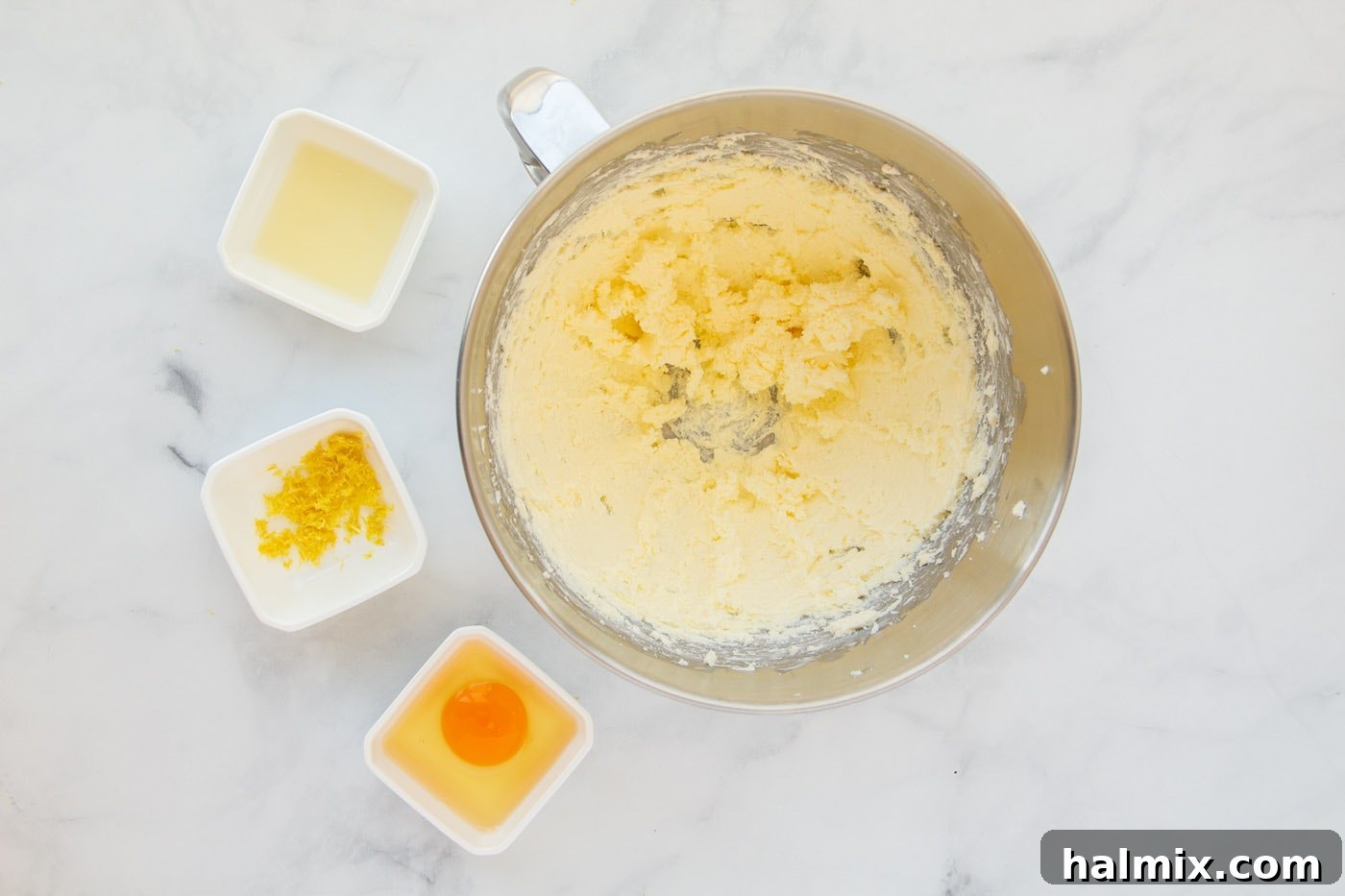 Zesty Lemon Cake Mix Cookies 5 Softened butter and cream cheese being beaten together in a bowl until creamy.