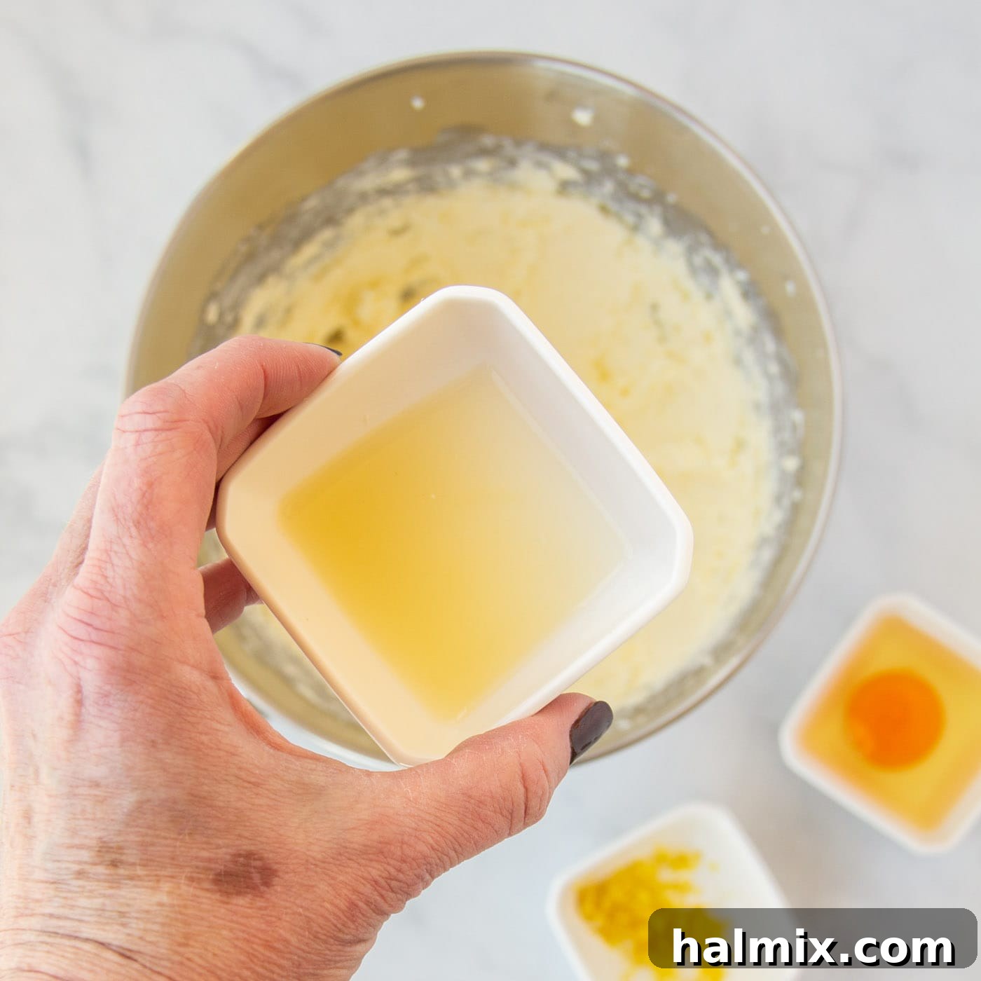 Zesty Lemon Cake Mix Cookies 6 Fresh lemon juice being poured over the cookie dough mixture in a bowl.