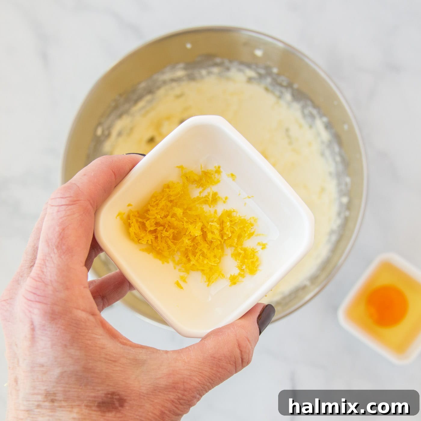 Zesty Lemon Cake Mix Cookies 7 Bright yellow lemon zest being added to the cookie dough mixture.