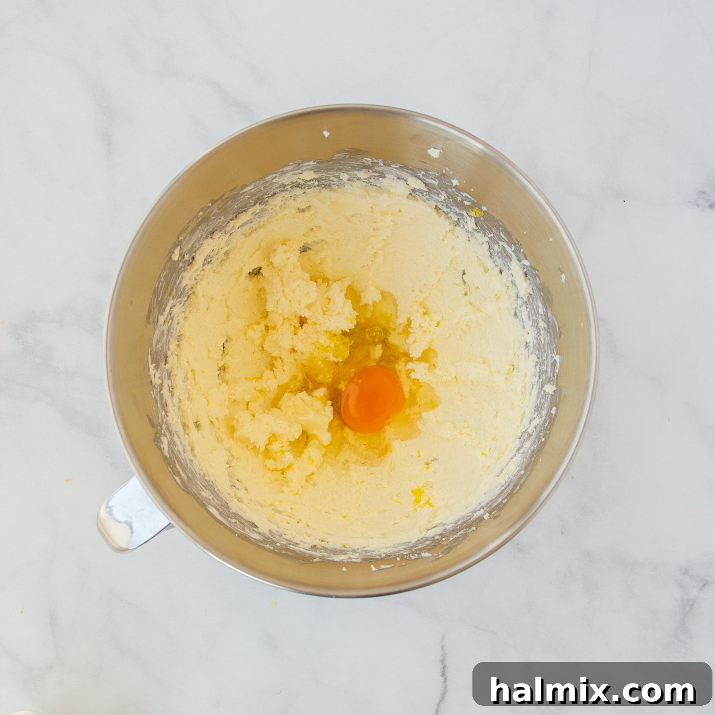 Zesty Lemon Cake Mix Cookies 8 Lemon juice, egg, and lemon zest thoroughly mixed into the cream cheese and butter base, creating a smooth, yellow mixture.