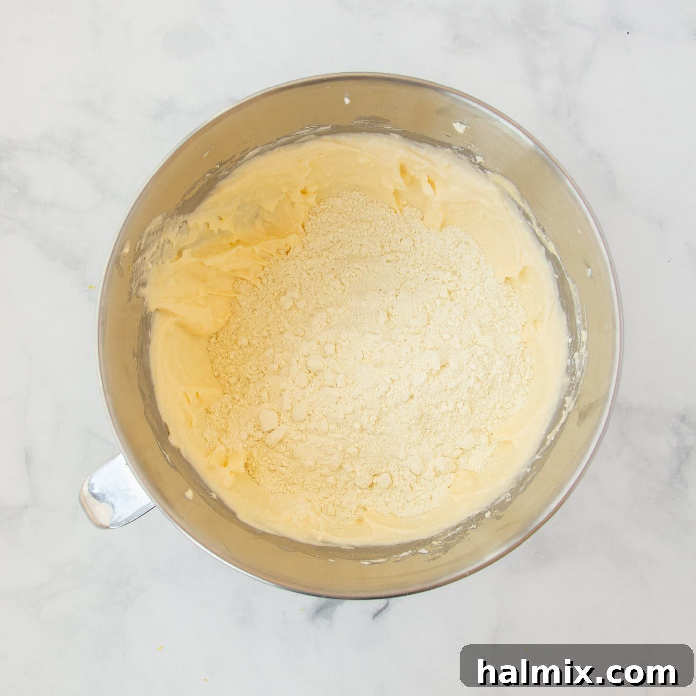 Zesty Lemon Cake Mix Cookies 9 The dry lemon cake mix being mixed into the creamy lemon cookie dough.