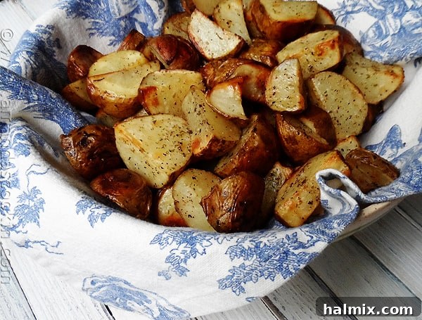A close-up photo of perfectly roasted potato wedges, golden brown and slightly crispy, seasoned with herbs, making a delicious side dish.