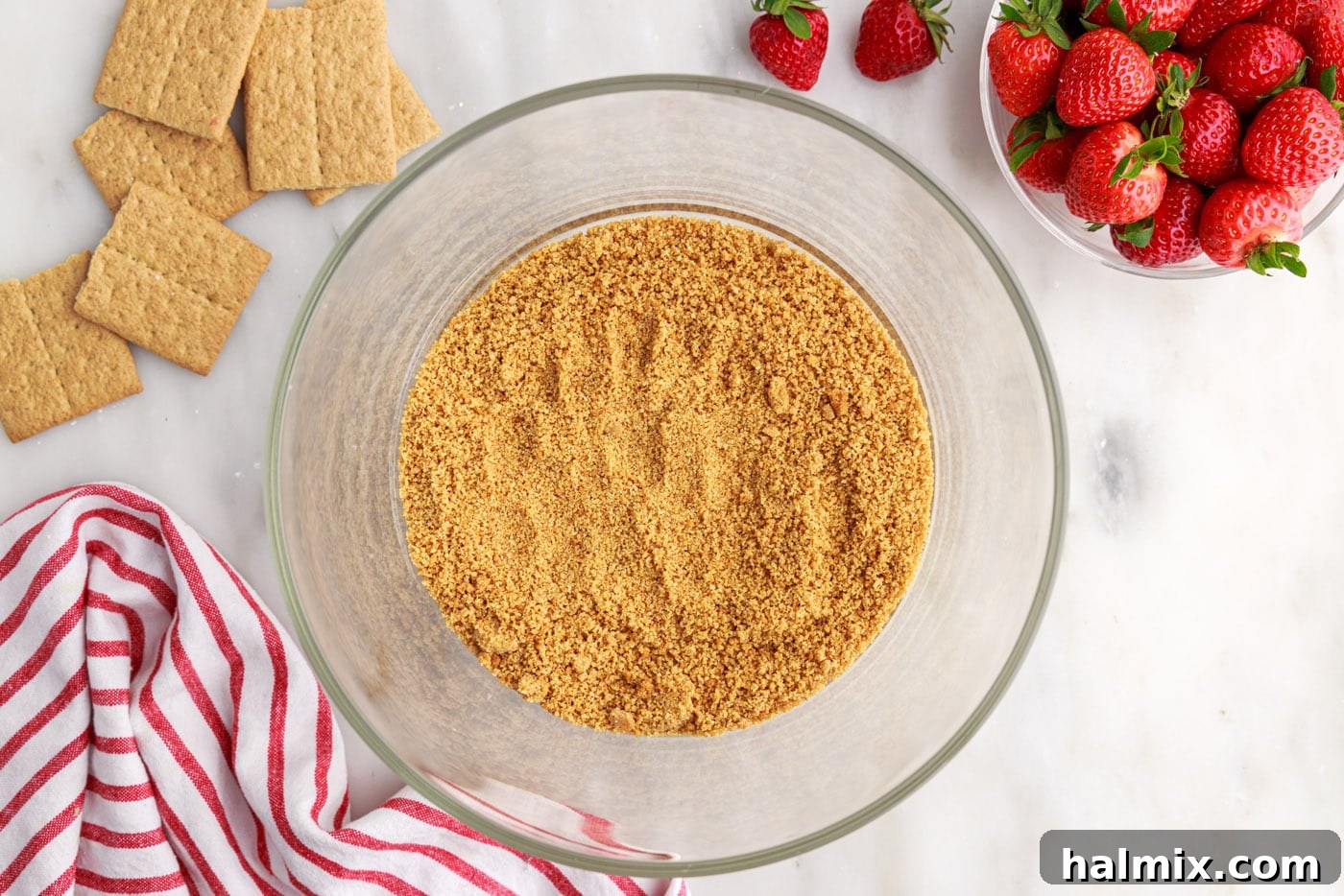 Strawberry Lasagna Delight 13 The first layer of toasted graham cracker crumbs neatly placed at the bottom of a clear trifle bowl.