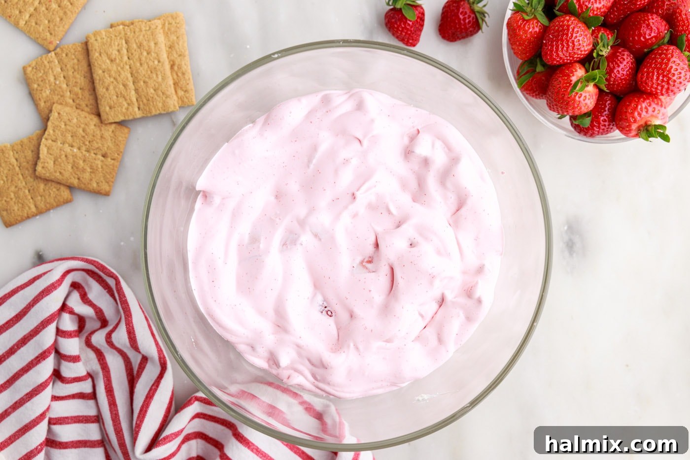 Strawberry Lasagna Delight 15 A vibrant pink layer of whipped strawberry jello mixture carefully spread over the cheesecake layer in a trifle bowl.