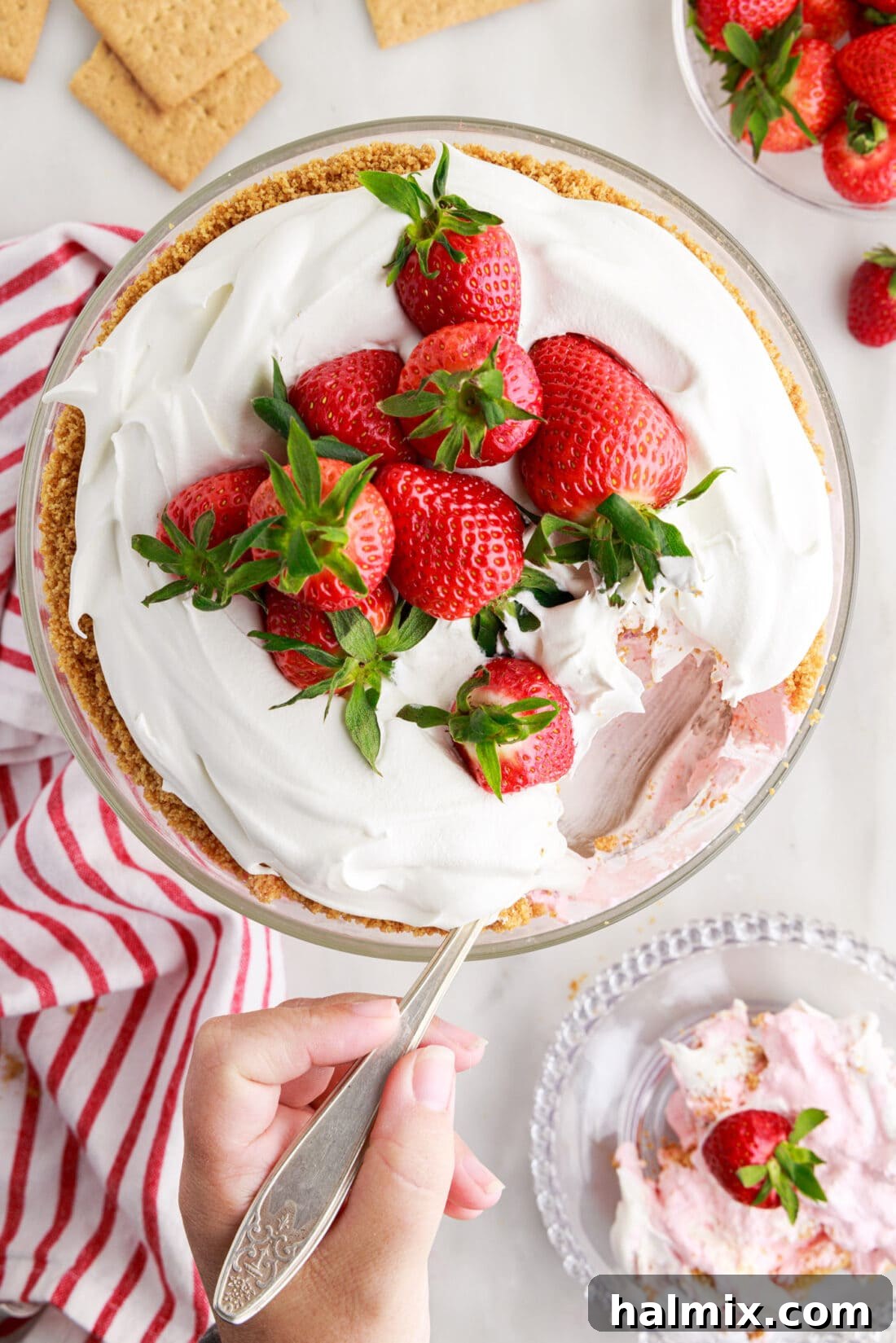 Strawberry Lasagna Delight 3 An overhead view of the Strawberry Lasagna Trifle with a portion elegantly scooped out, revealing the distinct layers of graham cracker, cheesecake, and strawberry mixture.
