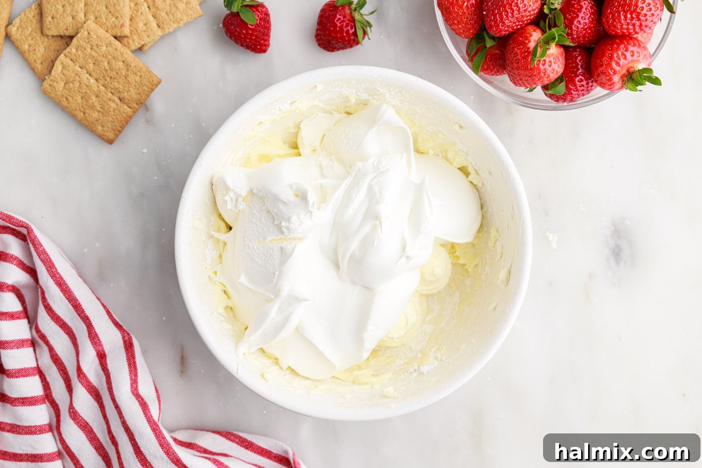 Strawberry Lasagna Delight 9 A dollop of Cool Whip on top of the cream cheese and powdered sugar mixture in a mixing bowl, ready to be folded in.