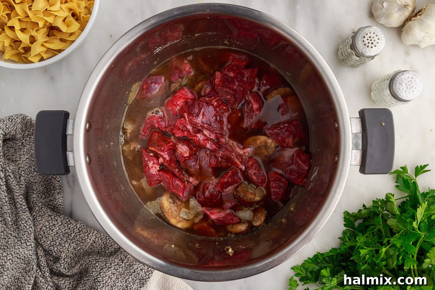 Beef, beef stock, seasonings, and Worcestershire sauce inside the Instant Pot, before pressure cooking.