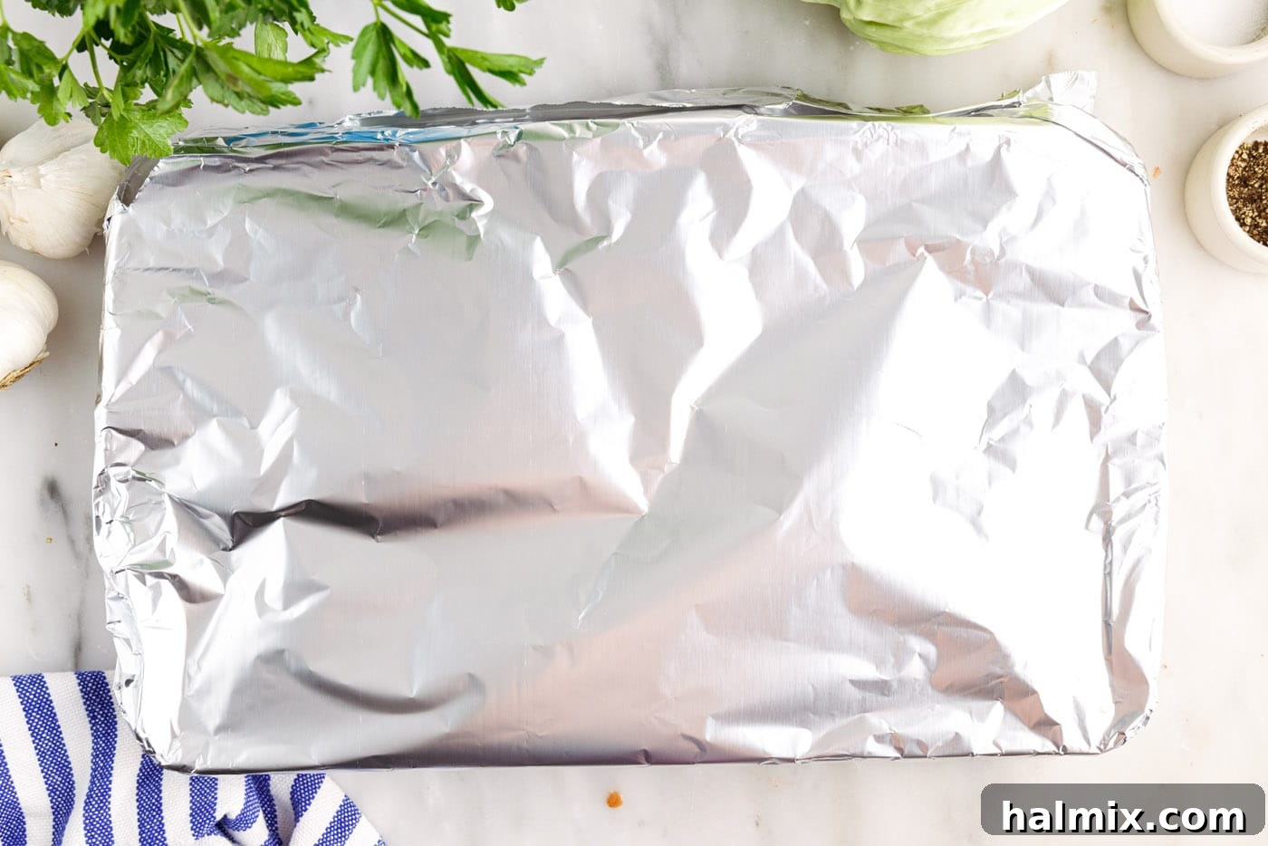 Savory Stuffed Cabbage Bundles 13 Casserole dish covered with aluminum foil, ready for baking in the oven.