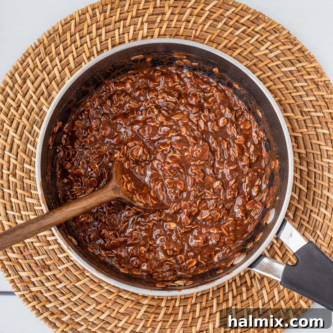 wooden spoon mixing no bake chocolate cookies in a saucepan