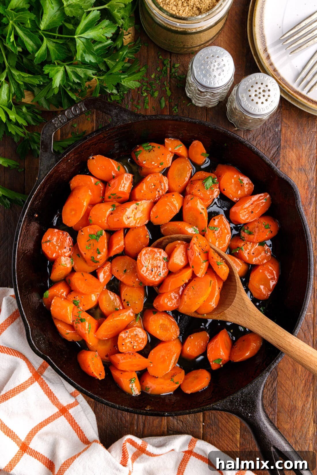 wooden spoon in skillet of Glazed Carrots