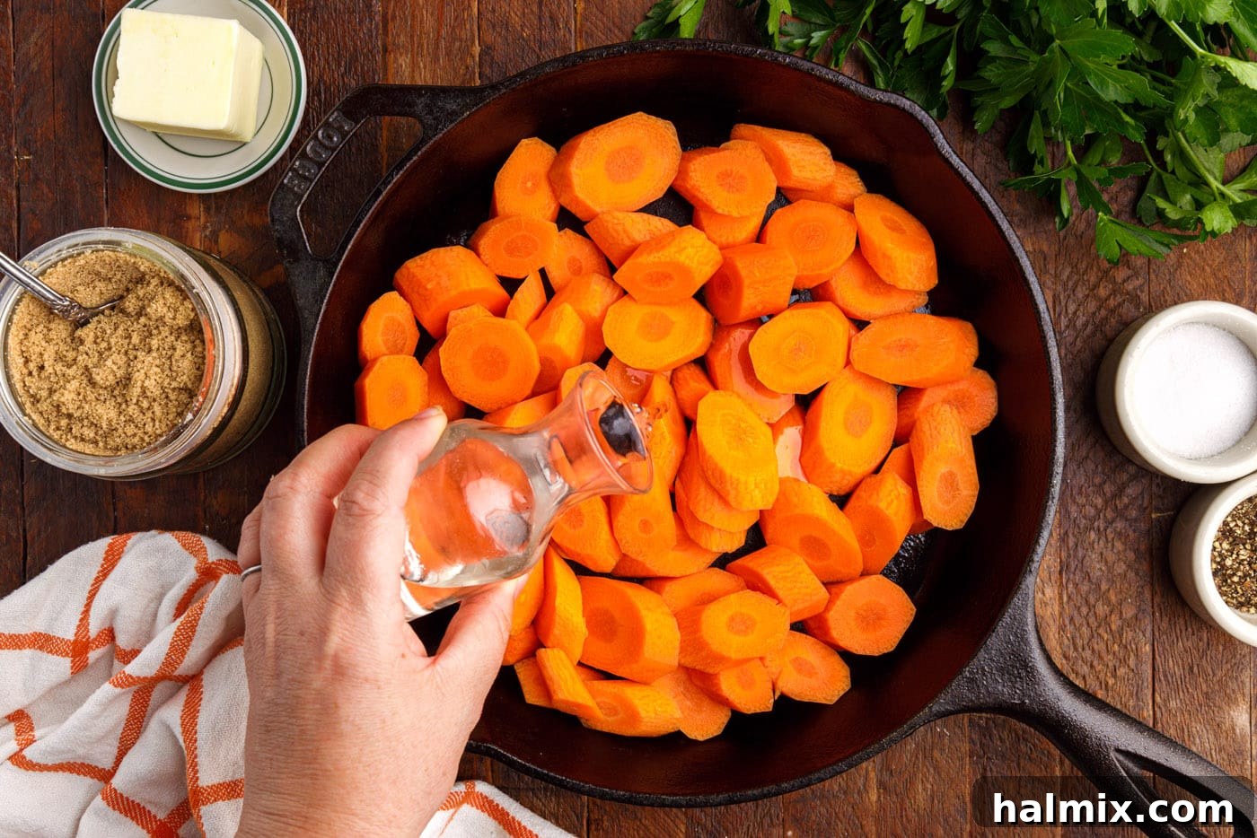 adding water to a skillet full of sliced carrots