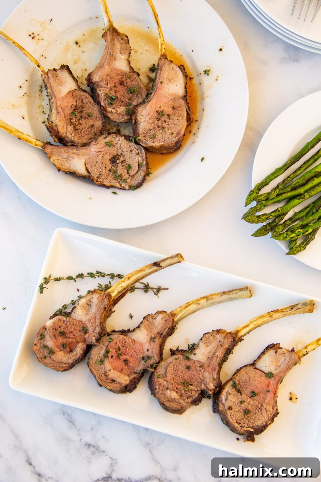 Rack of Lamb artfully cut into individual chops, served on plates with a side of fresh herbs.