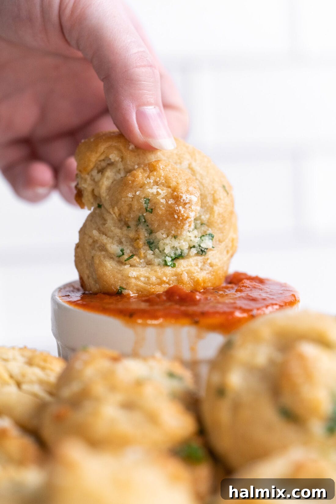 dipping a garlic knot into marinara