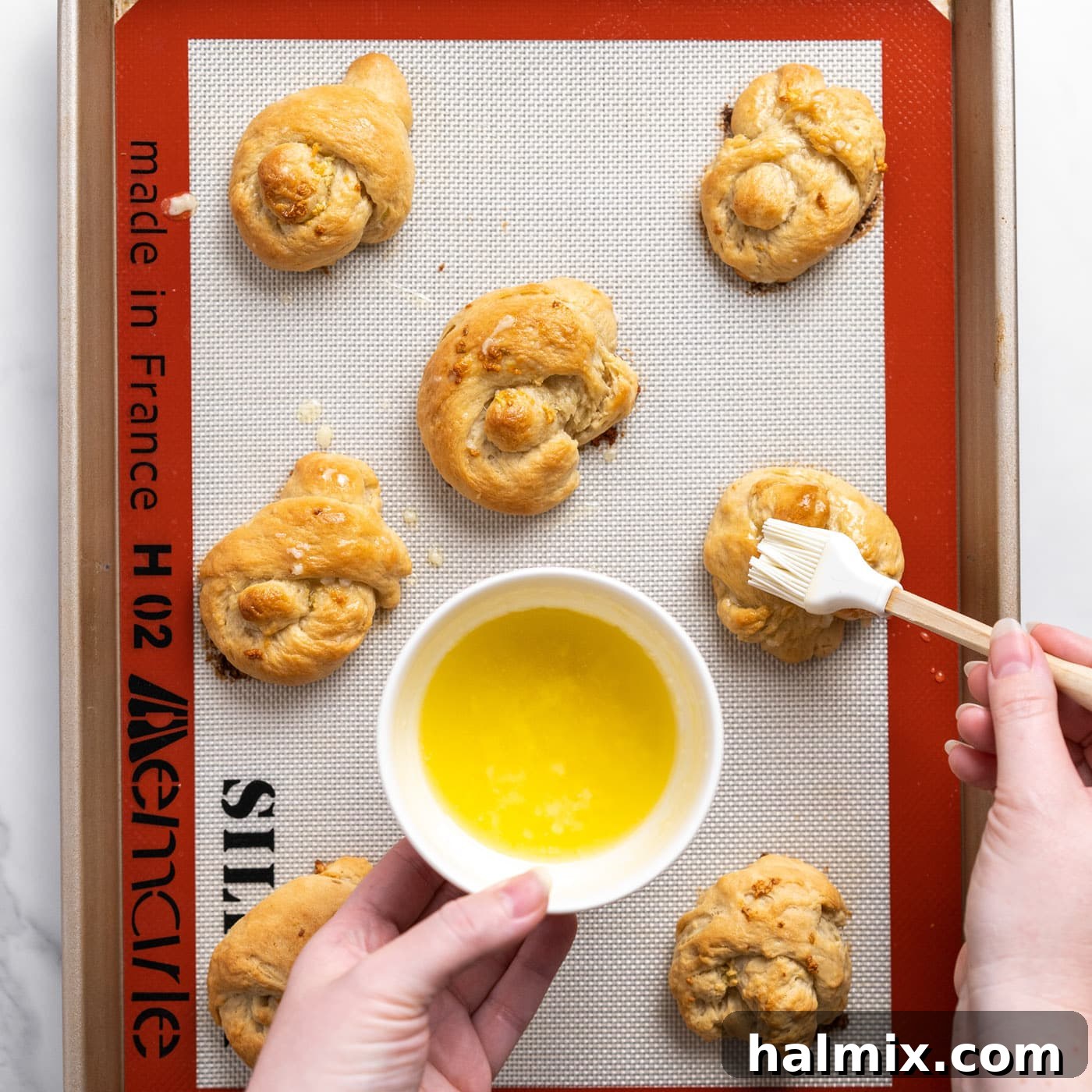 brushing extra garlic butter on top of garlic knots