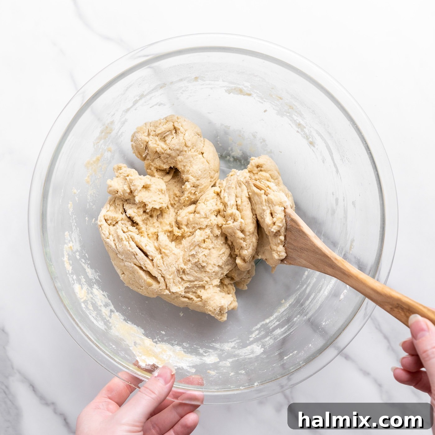 bread dough in a bowl with wooden spoon