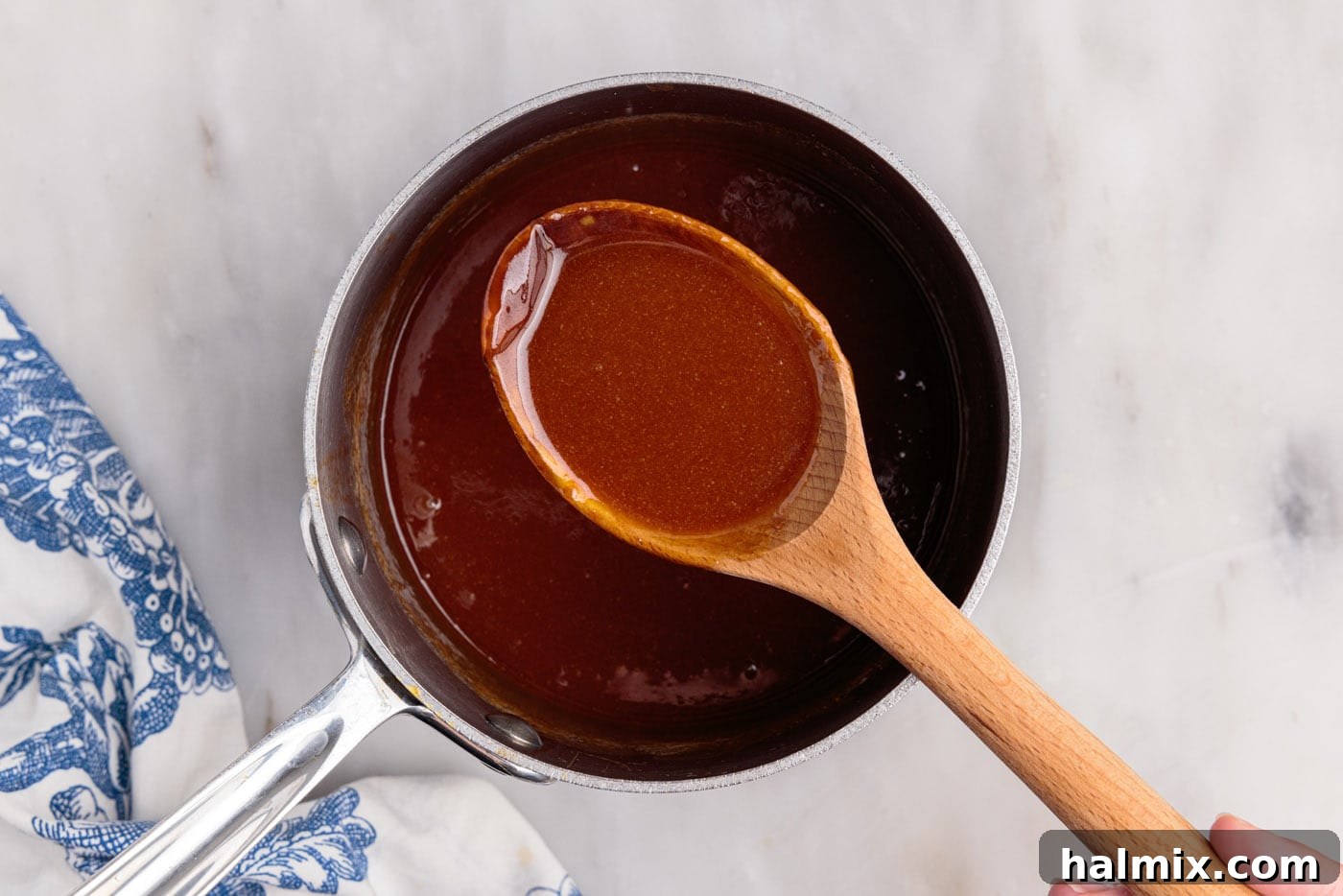wooden spoon holding caramel sauce
