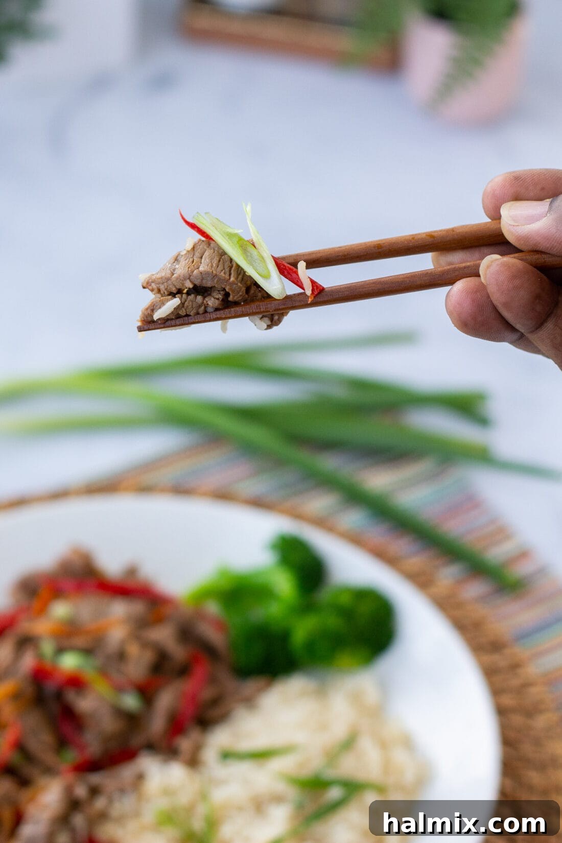 picking up Szechuan Beef with chopsticks