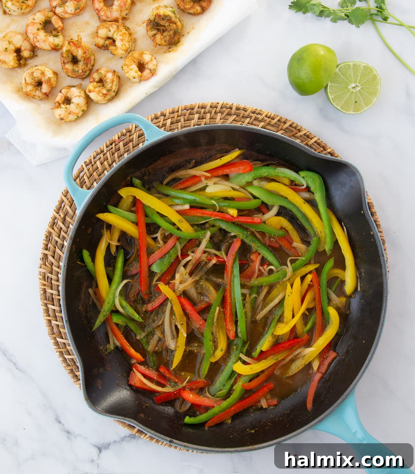 Bell peppers and onions sautéing in a skillet, creating a vibrant base for fajitas