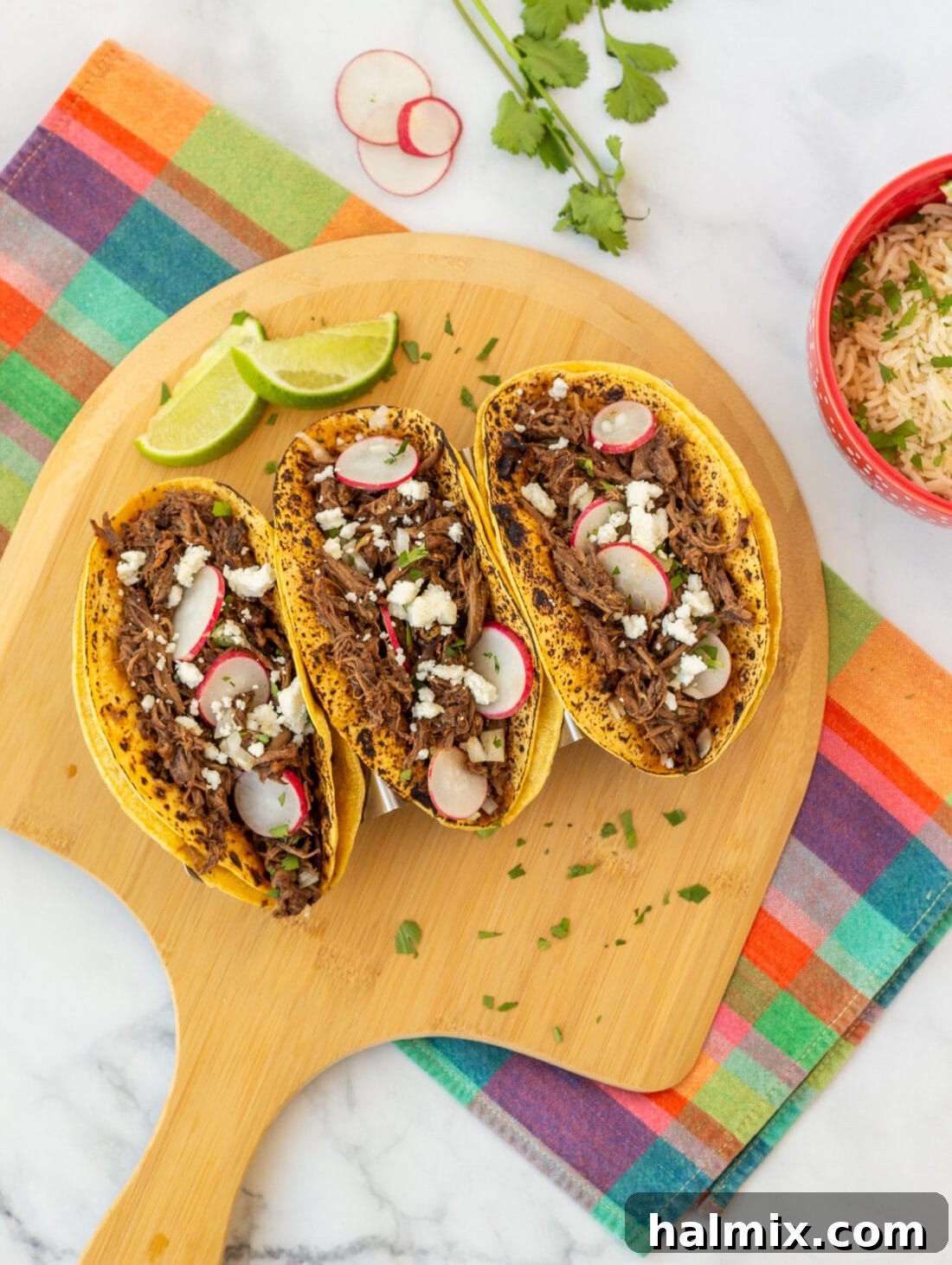 Meltingly Tender Barbacoa 5 Beef Barbacoa tortillas on a wooden platter