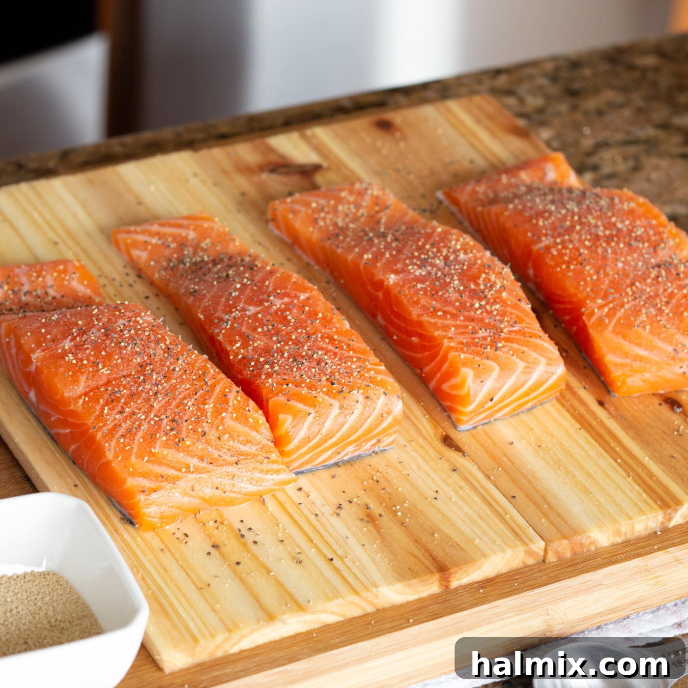 Seasoned salmon fillets arranged on cedar planks, ready for the glaze application.