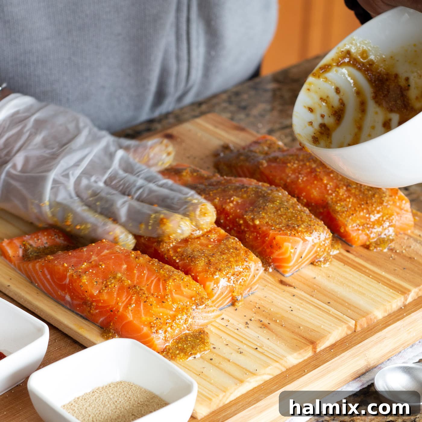 Applying the sweet and savory mustard glaze to the salmon fillets on cedar planks.