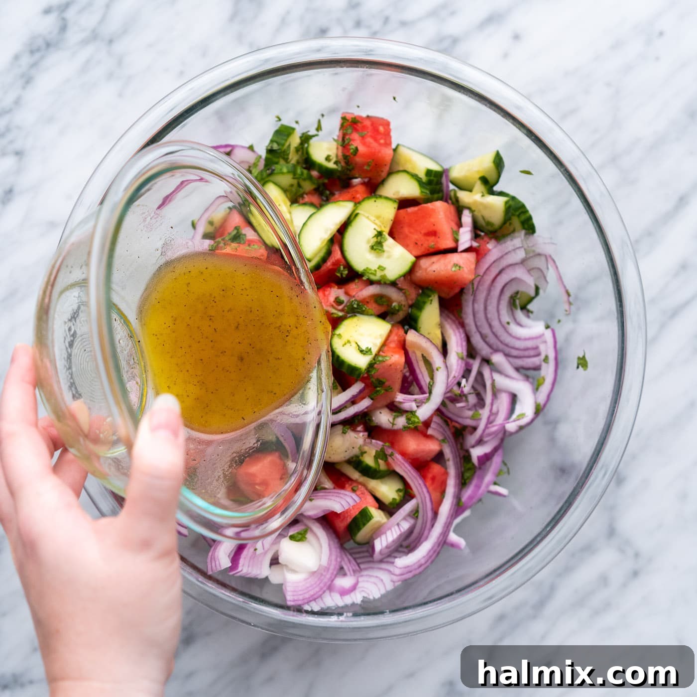 pouring vinaigrette into watermelon salad