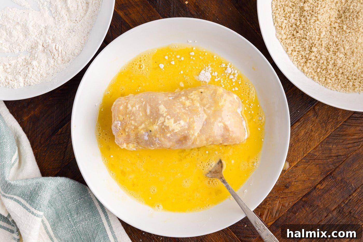 dredging rolled chicken in egg