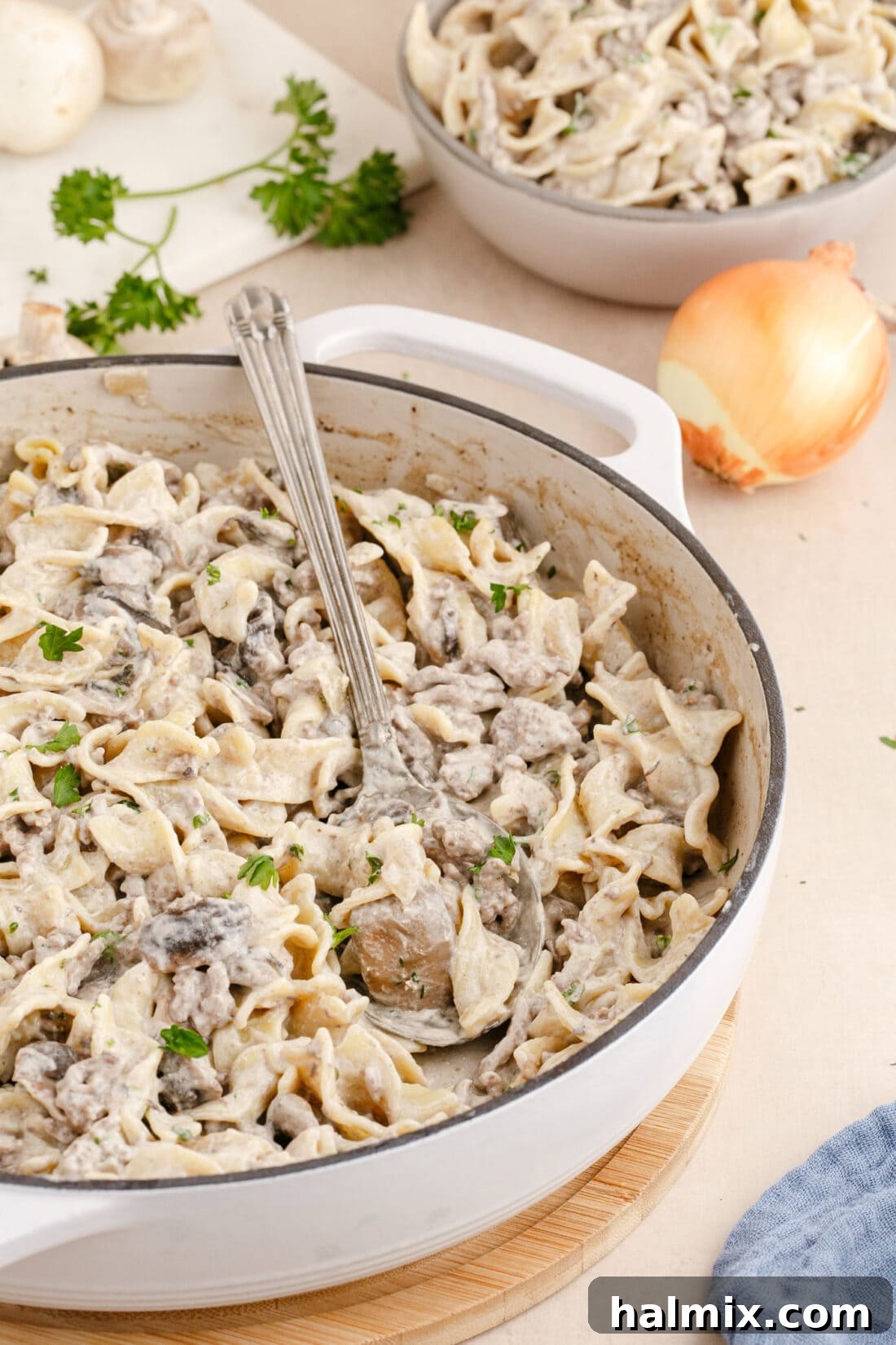 Creamy Ground Beef Stroganoff 12 A large serving spoon resting in a pan full of steaming Ground Beef Stroganoff, ready to be served.