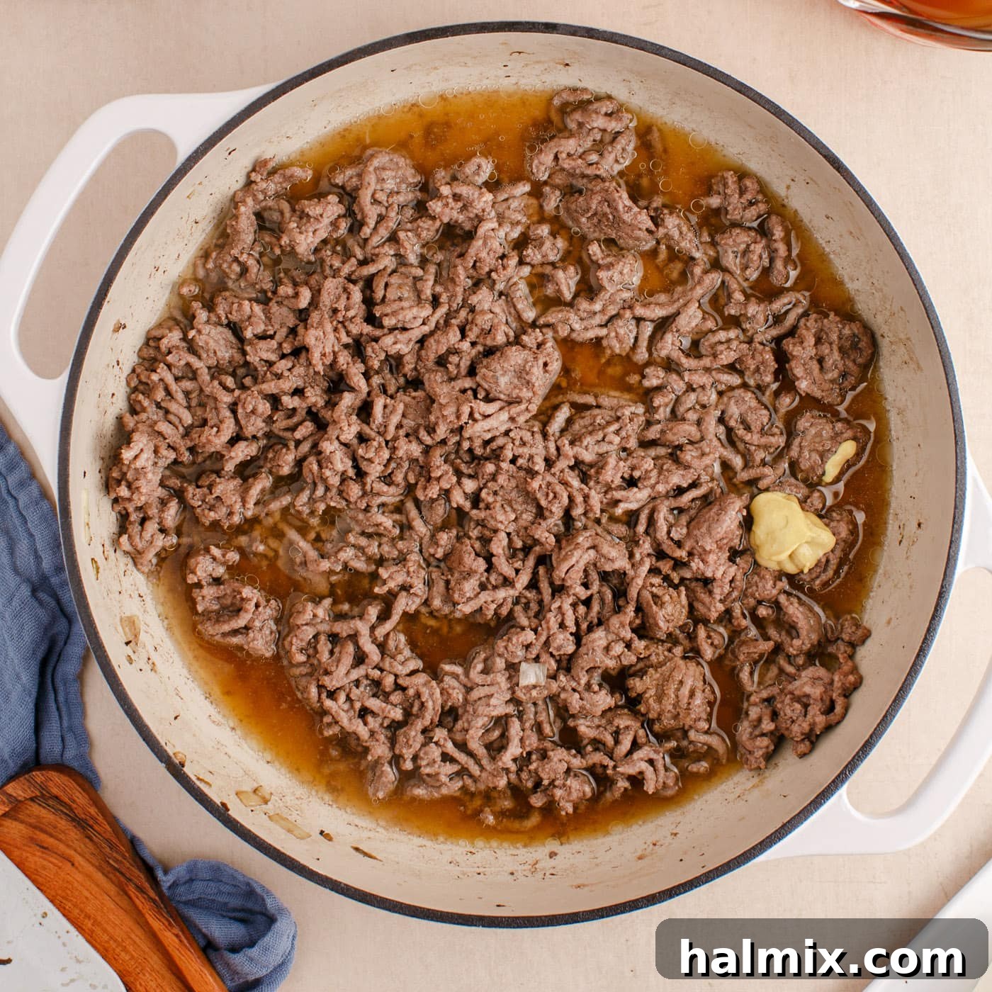 Creamy Ground Beef Stroganoff 7 Ground beef cooking in a skillet with beef broth, Worcestershire sauce, and Dijon mustard.