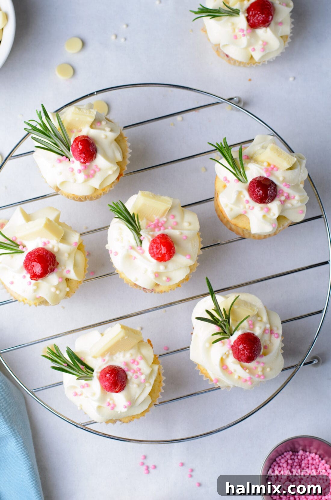 An overhead view of beautifully decorated Raspberry White Chocolate Cupcakes displayed on a wire rack