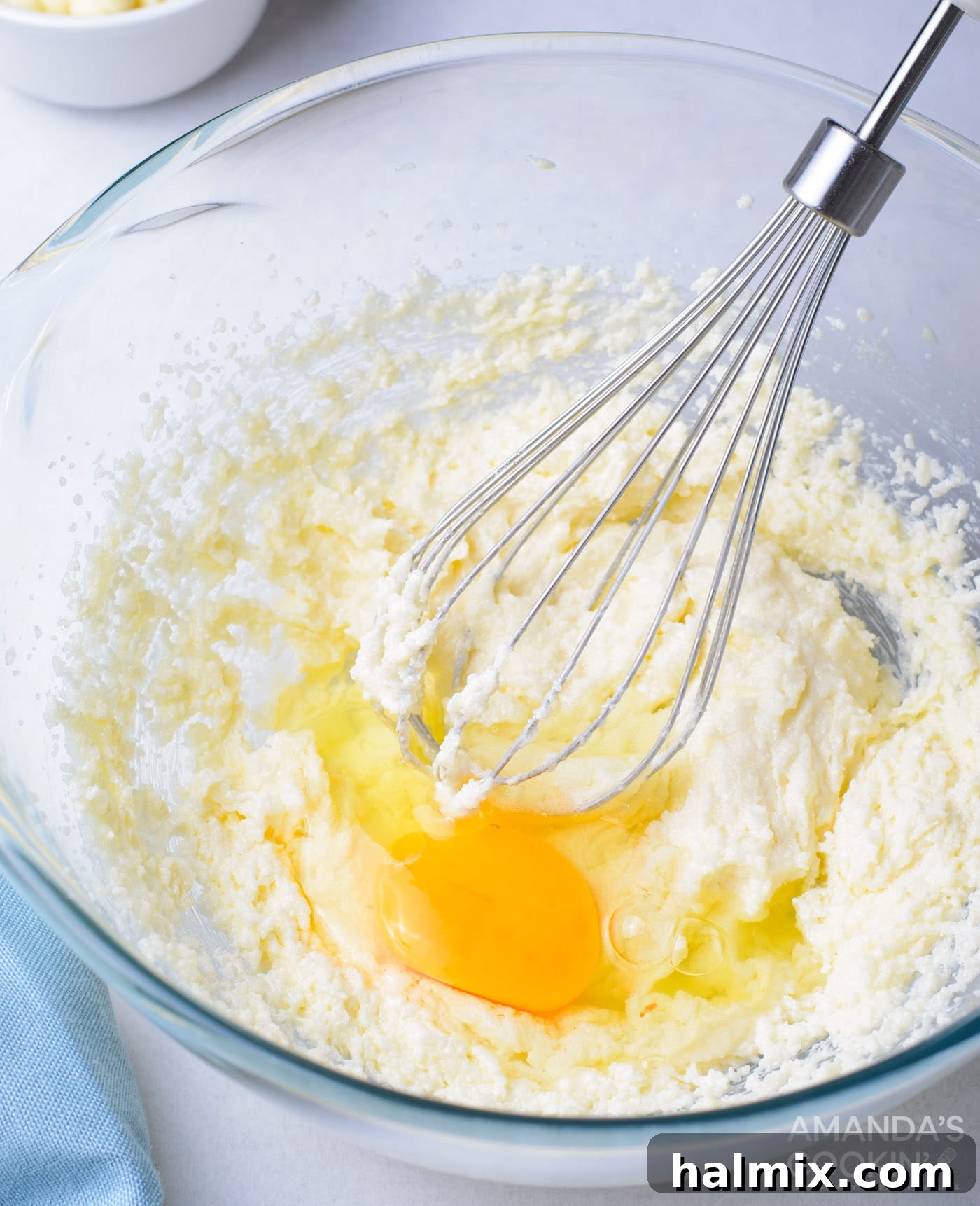 Mixing butter, vanilla, sugar, eggs, sour cream, and milk in a large bowl with an electric mixer for cupcake batter