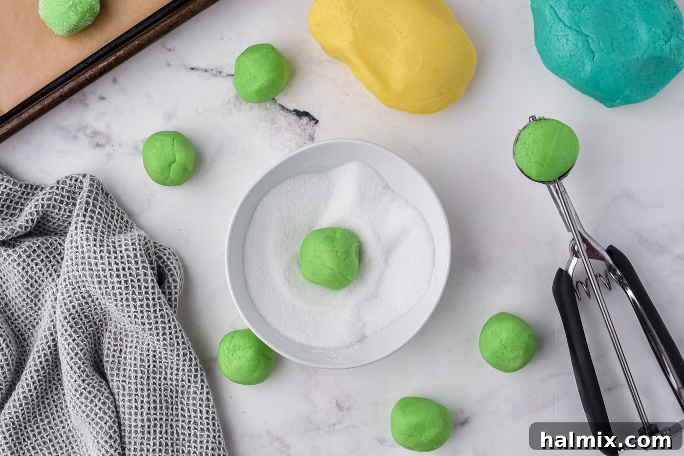jello cookie dough balls rolled in sugar and placed on a baking sheet