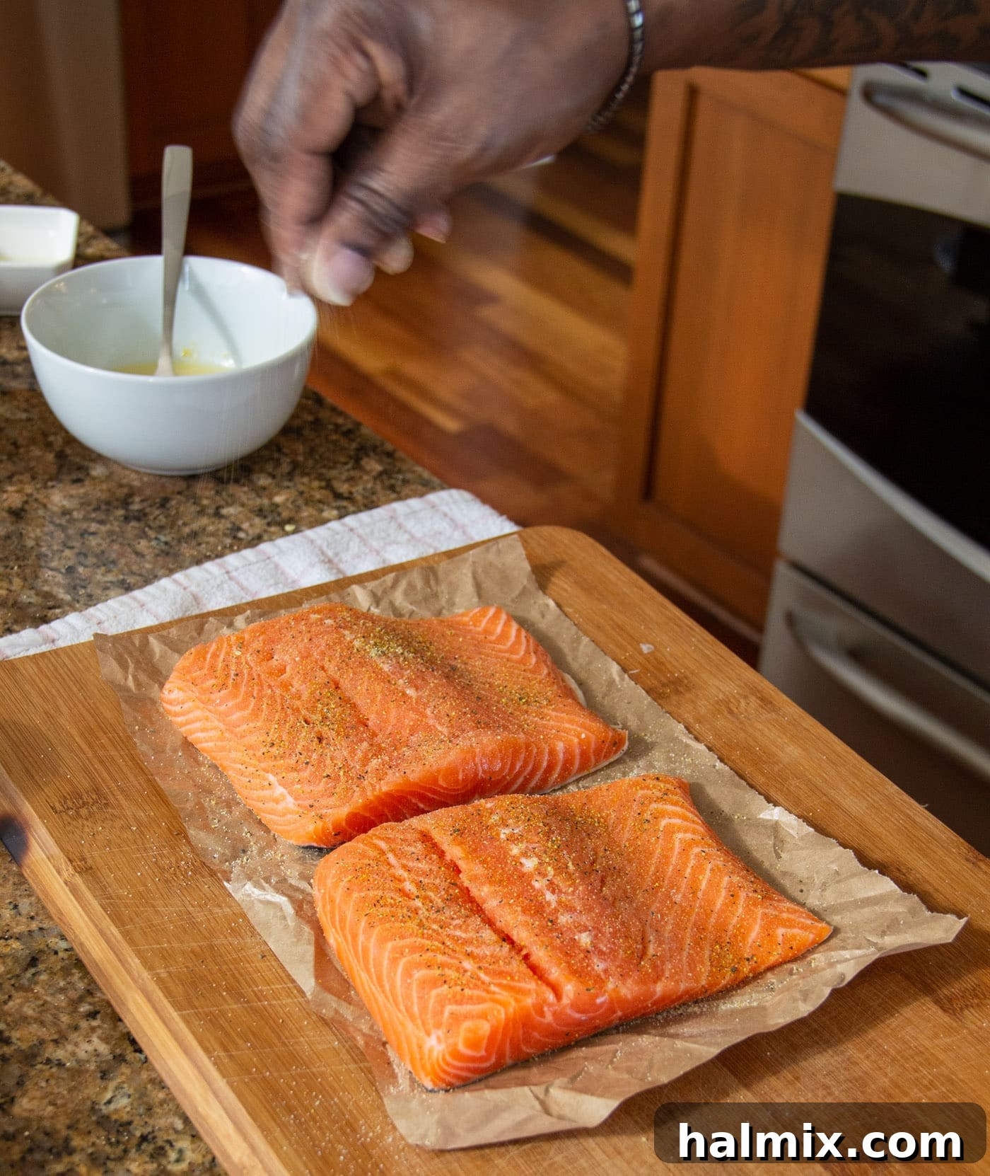 sprinkling lemon pepper and garlic salt on salmon