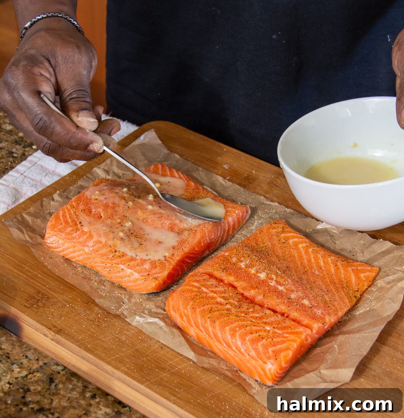 spooning lemon marinade over salmon
