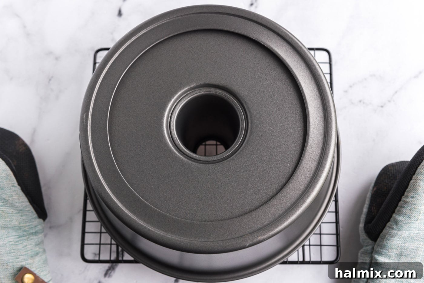 Feather-Light Angel Food Cake 12 Inverted angel food cake pan resting on a wire rack, allowing the cake to cool without collapsing