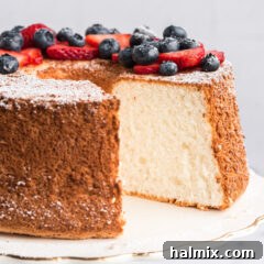Homemade Angel Food Cake with a slice removed, showing its light and airy texture