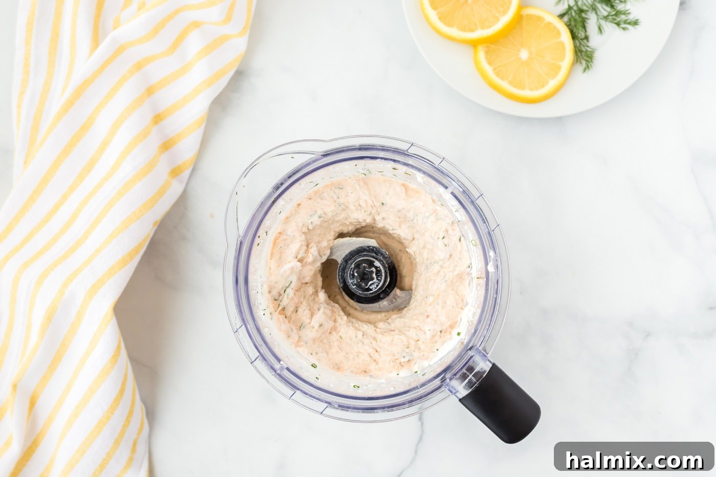 Perfectly blended Smoked Salmon Dip with small salmon chunks in a food processor bowl.