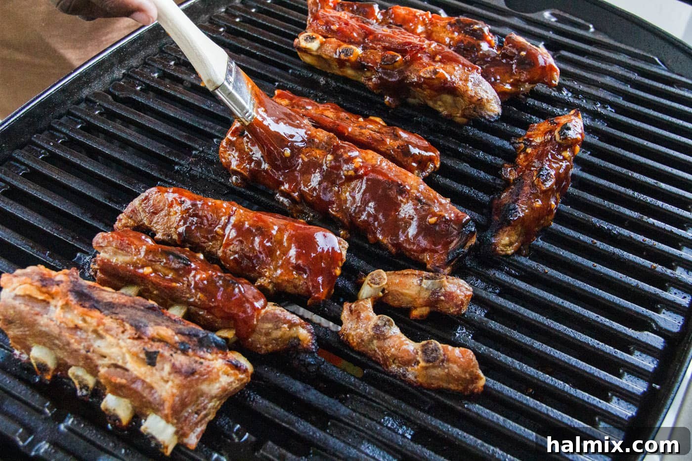 Smoked Rib Nuggets 6 brushing rib tips with barbecue sauce on the grill.