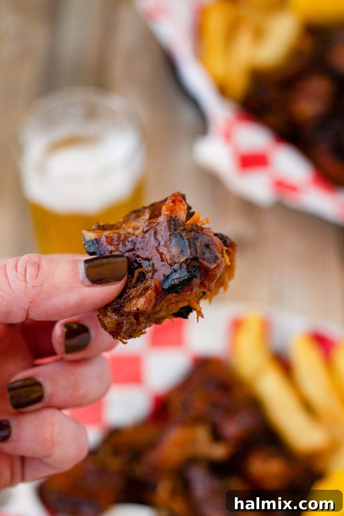 Smoked Rib Nuggets 8 holding a rib tip with tongs, showcasing its tenderness.