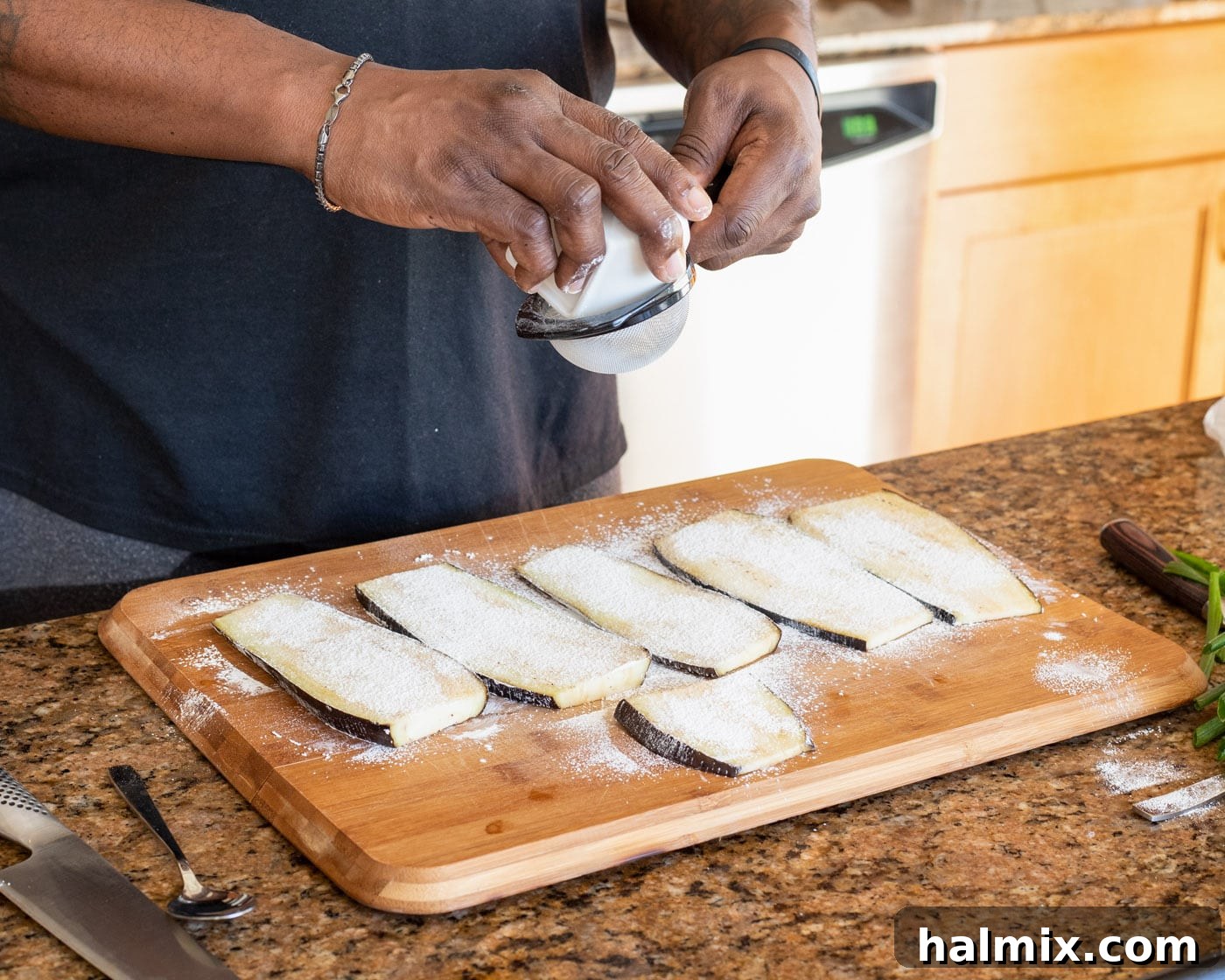 Sifting cornstarch over slices of eggplant