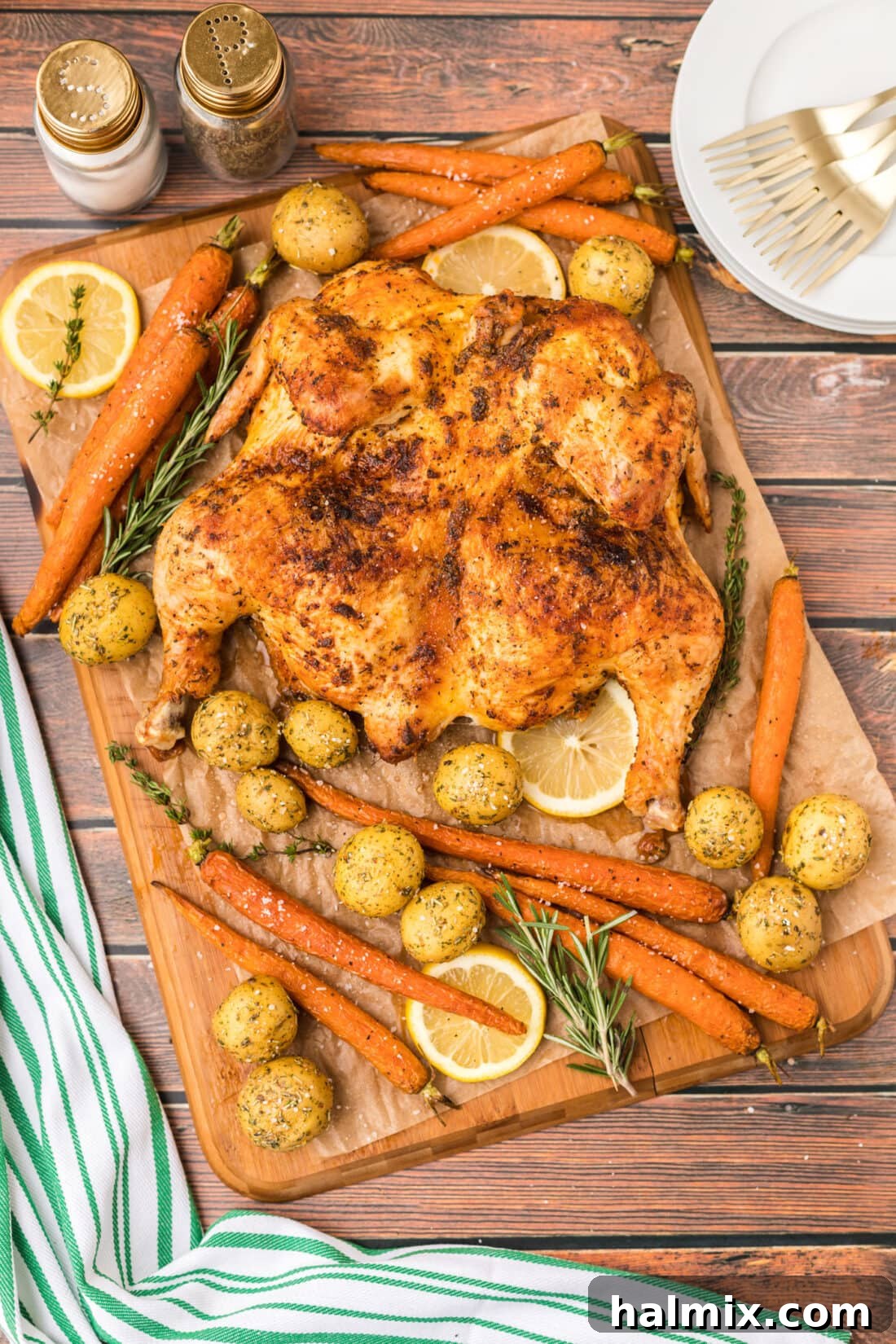 Spatchcock Chicken with roast vegetables on board, golden brown and crispy
