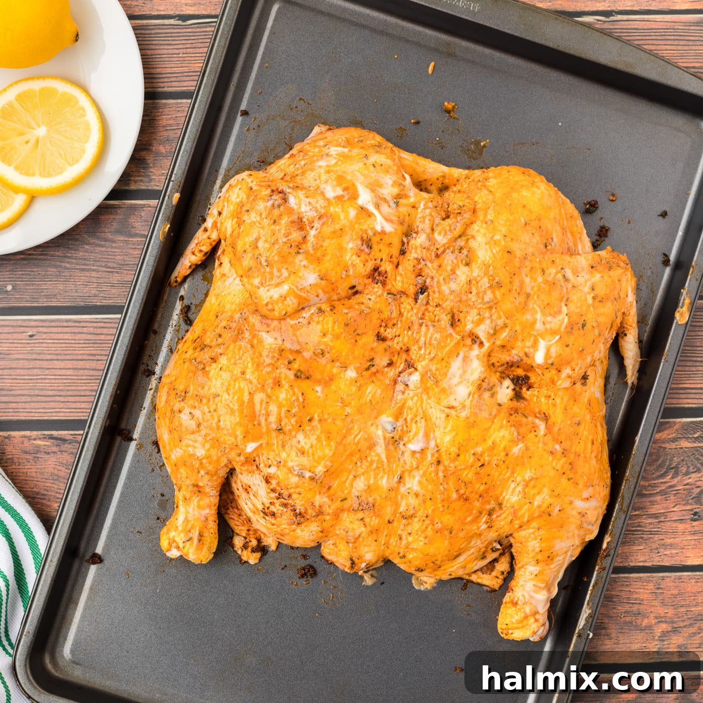 Spatchcock chicken on a baking tray ready for roasting