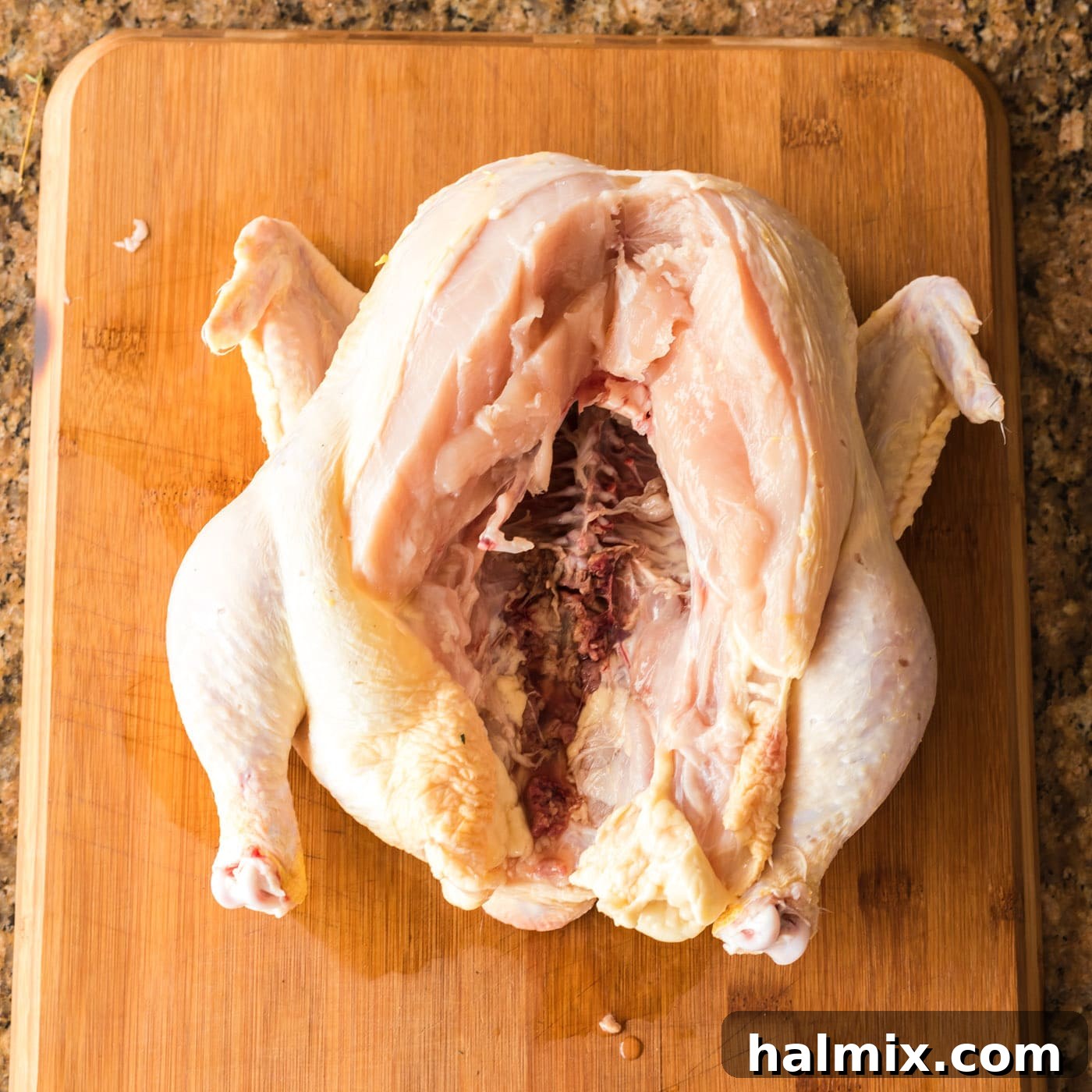 Removing the spine from a whole chicken with kitchen shears