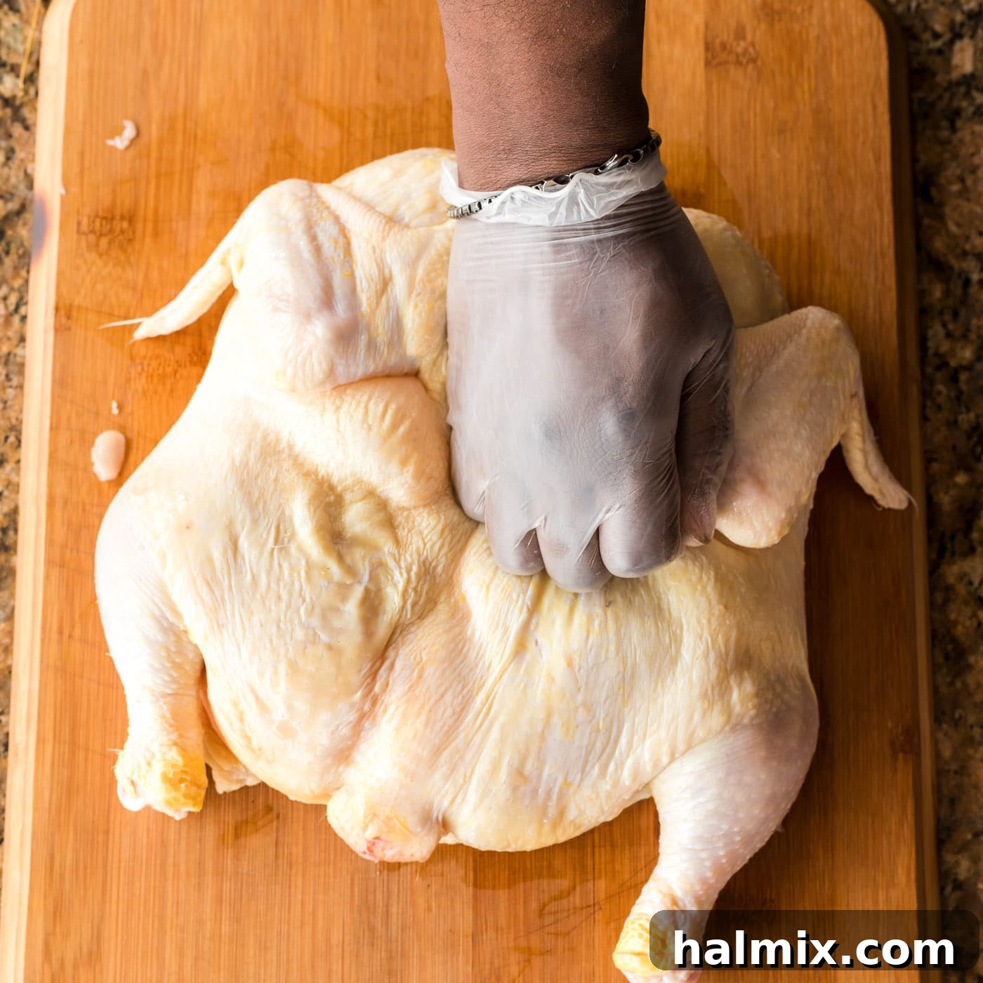 Flattening a spatchcock chicken on a cutting board