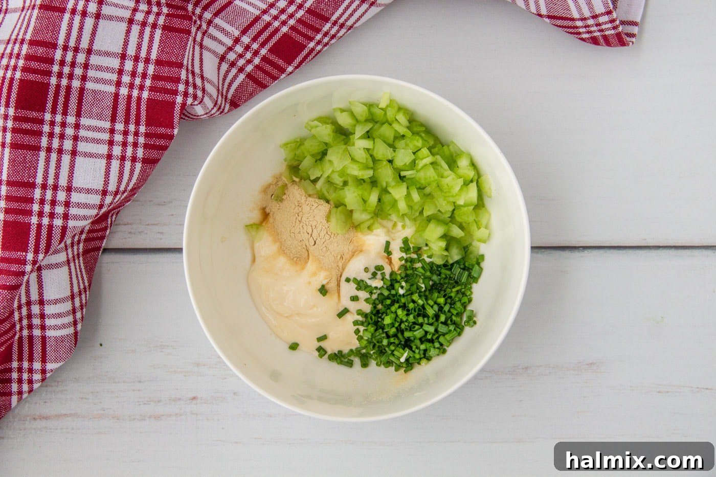 Mayonnaise-based dressing ingredients for lobster rolls mixed in a bowl, showing a creamy texture